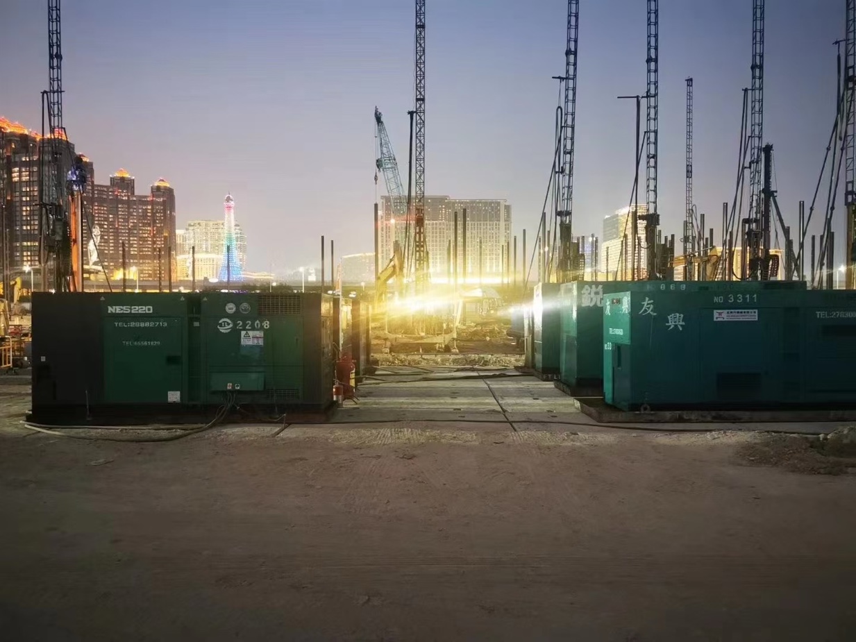 Jet grouting rigs and generator sets on site at dusk